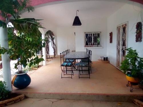 eine Terrasse mit einem Tisch und Stühlen in einem Zimmer in der Unterkunft Agréable Villa LuLu sur la côte - La Somone in Ngaparou