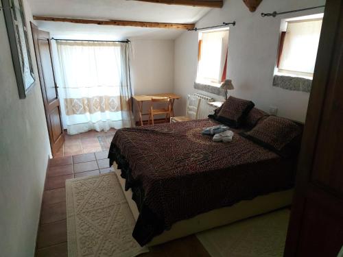 una camera da letto con un letto, un tavolo e finestre di Stazzo vista mare a San Teodoro