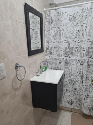 a bathroom with a sink and a shower curtain at Acogedor departamento 1 dormitorio in El Palomar