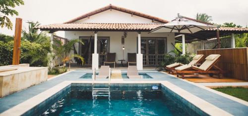 eine Villa mit einem Pool und einem Haus in der Unterkunft CASA ACAYU in São Miguel dos Milagres