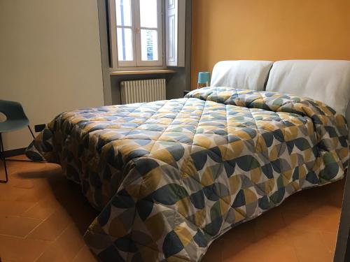 a bed in a bedroom with a blanket on it at Antica Dimora del Mercato in Domodossola