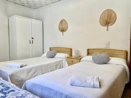 two beds in a room with white walls at Ca Àngela in Bolulla