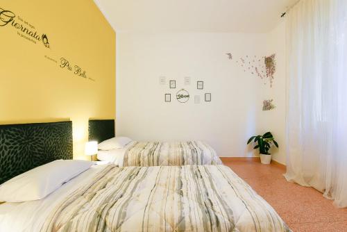 - une chambre avec 2 lits et de grands couvre-lits dans l'établissement We Home - Dall'ARA57 - Bologna Stadium, à Bologne