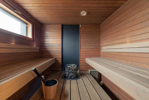a sauna with wooden walls and a window and benches at Villa Aurora in Rovaniemi