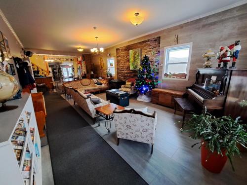 a living room with a christmas tree and a couch at Auberge Jeunesse à Loulou in Lévis