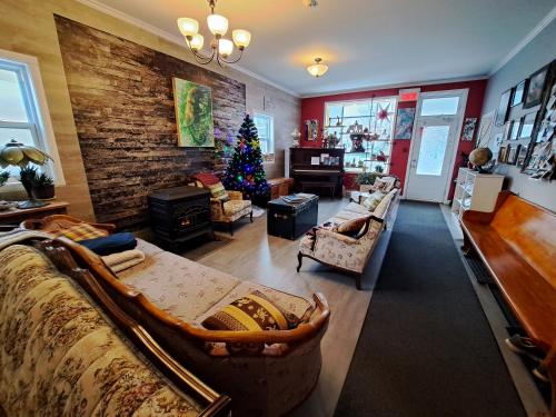 a living room with a christmas tree in the corner at Auberge Jeunesse à Loulou in Lévis