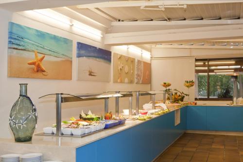 a buffet in a restaurant with food on a counter at Jutlandia Family Resort in Santa Ponsa