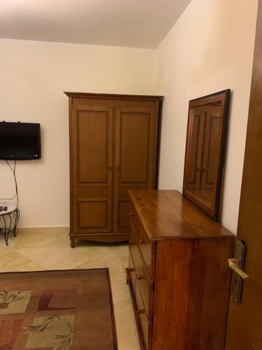 ein Zimmer mit einem Holzschreibtisch und einem Fernseher in der Unterkunft Maadi Nerco in Kairo