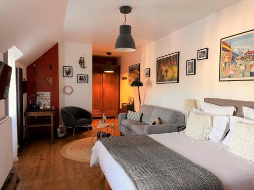 une chambre d'hôtel avec un lit et un canapé dans l'établissement La Récréation, à Châtelaudren