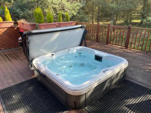 Felton的住宿－Jasmine Lodge, 2 bedroom with hot tub - Felmoor Park，甲板上的一个热水浴缸