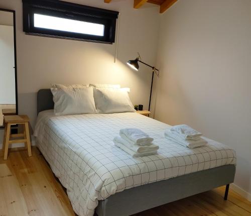 1 dormitorio con 1 cama con toallas en Casa d´ Avó Glória, en Alvoco das Várzeas