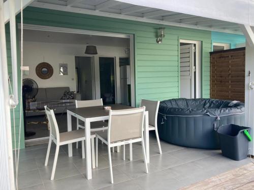 a patio with a table and chairs and a large tub at Appartement Shenandoah in Sainte-Anne