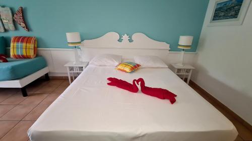 a bedroom with a white bed with red shoes on it at Studio Premium Vue Mer, Plage in Sainte-Luce