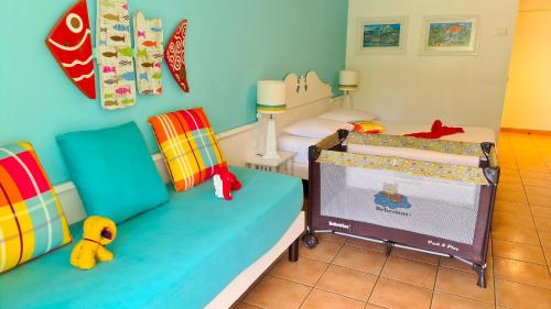 Zimmer mit 2 Betten und einem Kinderbett in der Unterkunft Studio Premium Vue Mer, Plage in Sainte-Luce