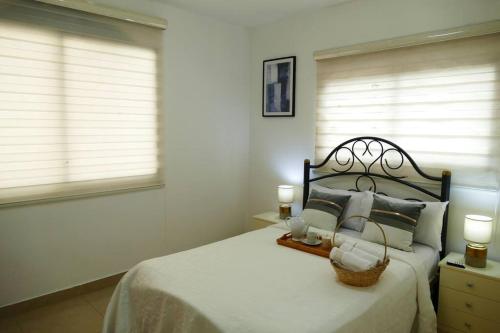 a bedroom with a large bed with two windows at Condominio Charito Suite 2G a 12 Min Malecon 2000 in Guayaquil