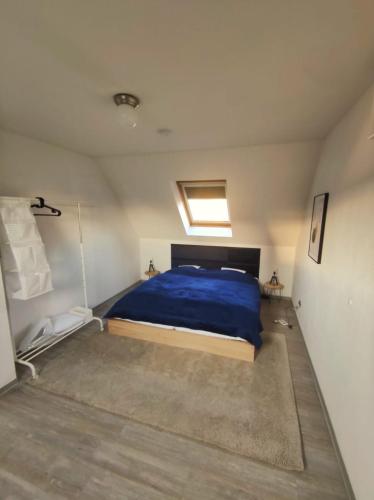 - une chambre avec un lit et une couette bleue dans l'établissement Dachgeschosswohnung mit Klimaanlage in bester Lage, à Menden