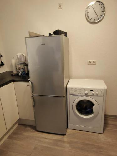a kitchen with a refrigerator and a washing machine and a clock at Dachgeschosswohnung mit Klimaanlage in bester Lage in Menden