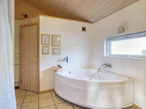 a large white tub in a bathroom with a window at 8 person holiday home in R dby in Rødby