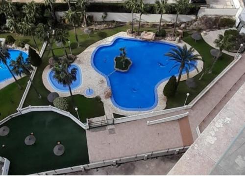 widok z góry na basen w ośrodku wypoczynkowym w obiekcie Precioso apartamento con piscina cerca de la playa w mieście Benidorm