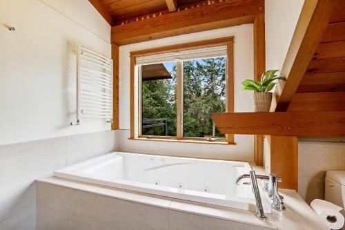 a bath tub in a bathroom with a window at Bainbridge Island Timber Retreat in Fort Ward