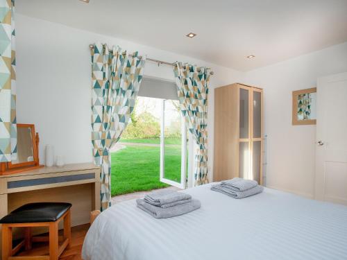 a bedroom with a bed and a large window at Wonkey Donkey Cottage in Salcombe Regis