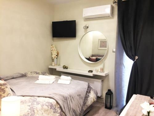 een slaapkamer met een bed en een grote spiegel bij Tiny Deluxe Suite in Kalamaria in Thessaloniki