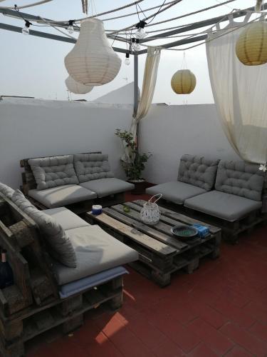 a living room with couches and a table and lamps at Habitación Hinojo in Sanlúcar de Barrameda
