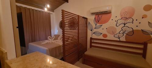 a room with a bed and a wall with flowers at Solar Águas Pipa Prime in Pipa