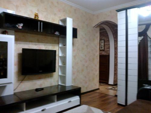 a living room with a flat screen tv on a wall at Apartments on Proletarskaya in Sumy