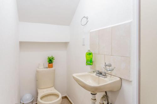 a white bathroom with a toilet and a sink at Casa Familiar Sian Kaan in Caucel