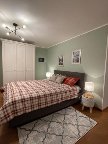 1 dormitorio con 1 cama con manta a cuadros en Appartamento Verena en Dobbiaco