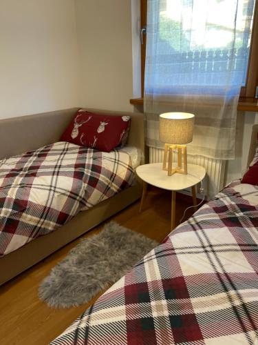 una camera con due letti e un tavolo con una lampada di Appartamento Verena a Dobbiaco