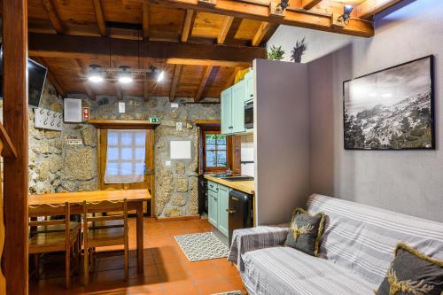 a kitchen and living room with a couch and a table at Casa do Tio Ferreiro in Sabugueiro