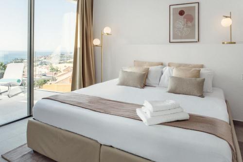een slaapkamer met een groot wit bed en een groot raam bij Villa Felicity in Adeje