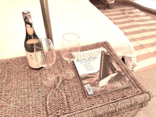 a table with two glasses and a bottle of wine at Golden Point Glamping in Faraday