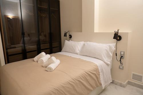 - un lit blanc avec 2 serviettes dans l'établissement El Arenal apartment, à Séville