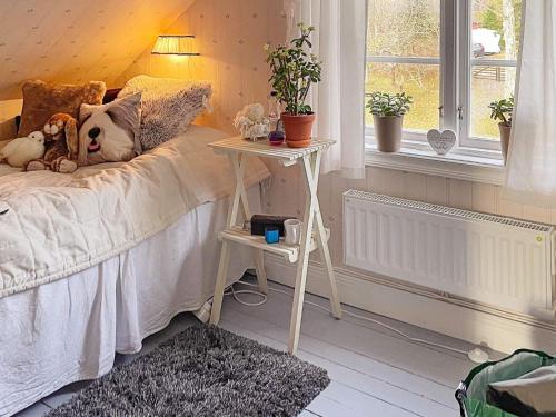 a bed with a side table next to a window at 5 person holiday home in BJÖRKÖ-By Traum in Björkö