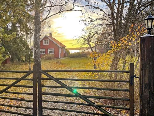 a gate with a fence in front of a red house at 5 person holiday home in BJÖRKÖ-By Traum in Björkö