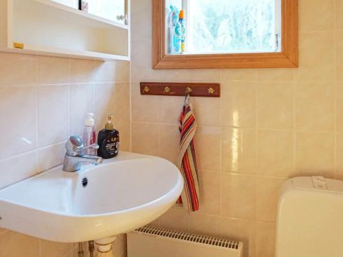 a bathroom with a sink and a toilet and a window at Holiday home Fjällbacka VII in Fjällbacka