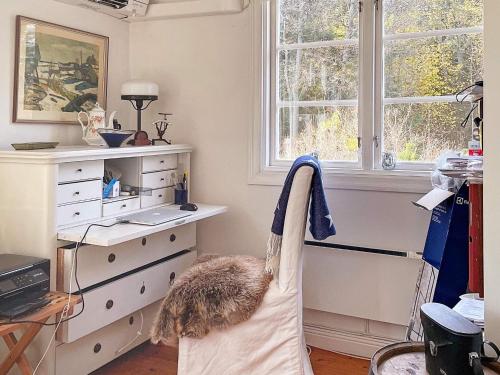a bedroom with a dresser and a chair with a robe at 5 person holiday home in BJÖRKÖ-By Traum in Björkö