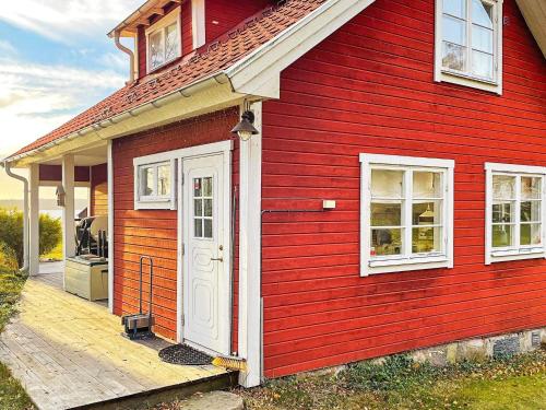 a red house with a white door and a porch at 5 person holiday home in BJÖRKÖ-By Traum in Björkö