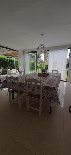 een eetkamer met een tafel en stoelen en een kroonluchter bij Family House Los Cuatro Robles in San Pedro