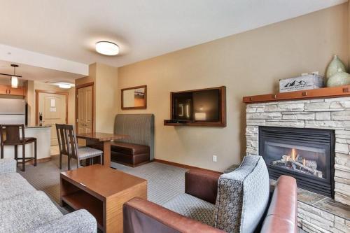 ein Wohnzimmer mit einem Sofa und einem Kamin in der Unterkunft B&B Falcon Crest Lodge 1BR 1Pullout in Canmore