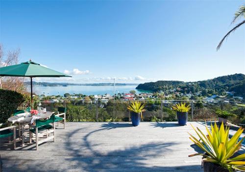 a patio with a table and a green umbrella at Views Over Russell in Russell