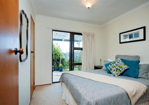 a bedroom with a bed with blue pillows at Views Over Russell in Russell