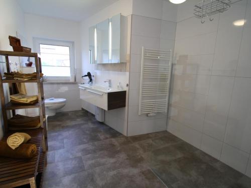 a white bathroom with a sink and a toilet at charming apartment with fireplace in Zarchlin