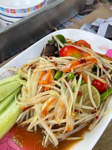 a plate of food with noodles and vegetables on a table at Hacker's Hill Camping & Resort in Suan Phung
