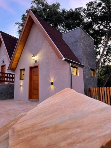 a small white house with a wooden door at VILLA ITÁLIA CHALÉ in Santo Antônio do Pinhal