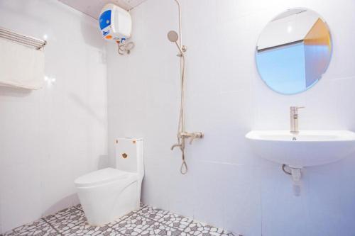 een badkamer met een wastafel, een toilet en een spiegel bij Lucky Home in Hue