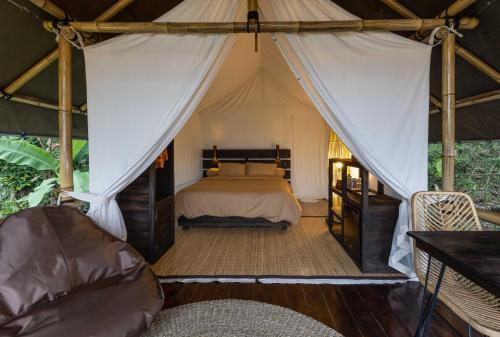 um quarto com uma cama numa tenda em Sanda Plantation Hideaway em Sanda